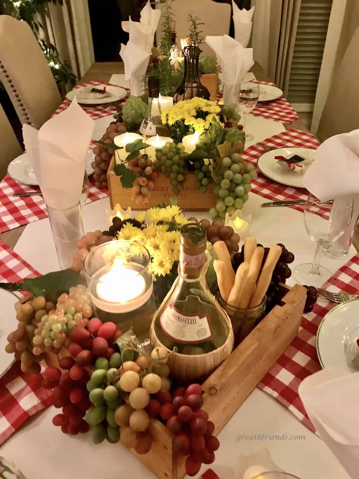 Table setting with a Chicago's Little Italy theme using red and white checked linen and flowers, chianti bottles, plastic grapes and candles. 