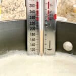 Pan of heating milk with thermometer on side of pan.