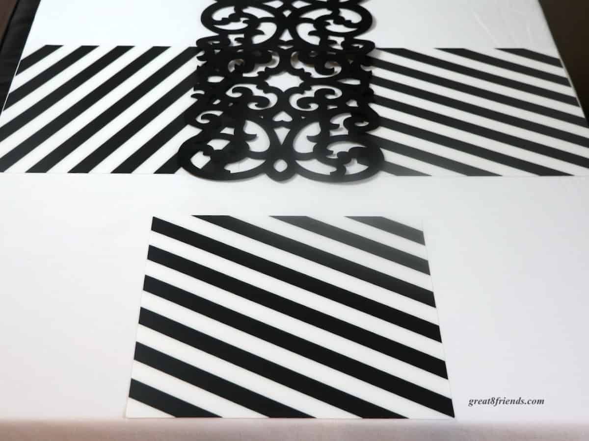 Black and white diagonal stripe placemats on white tablecloth.