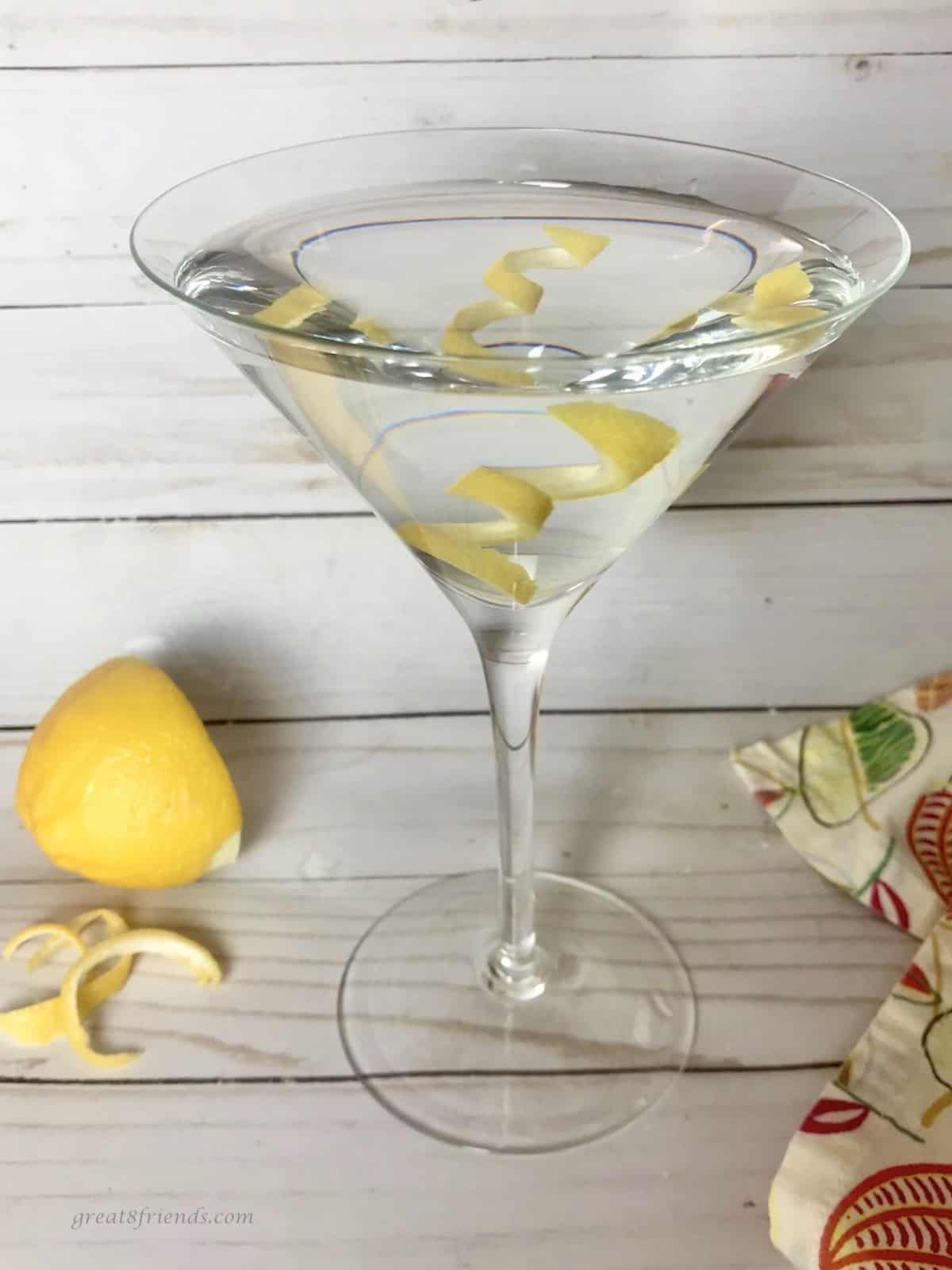 A martini with served with lemon peel as garnish in the glass.