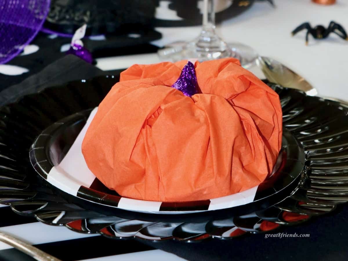 Paper pumpkin on black plate.