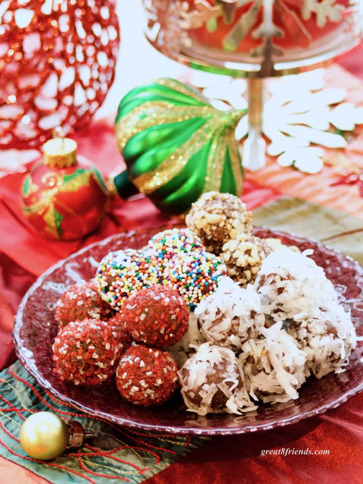 Chocolate truffles rolled in sprinkles and coconut on a Christmas table.