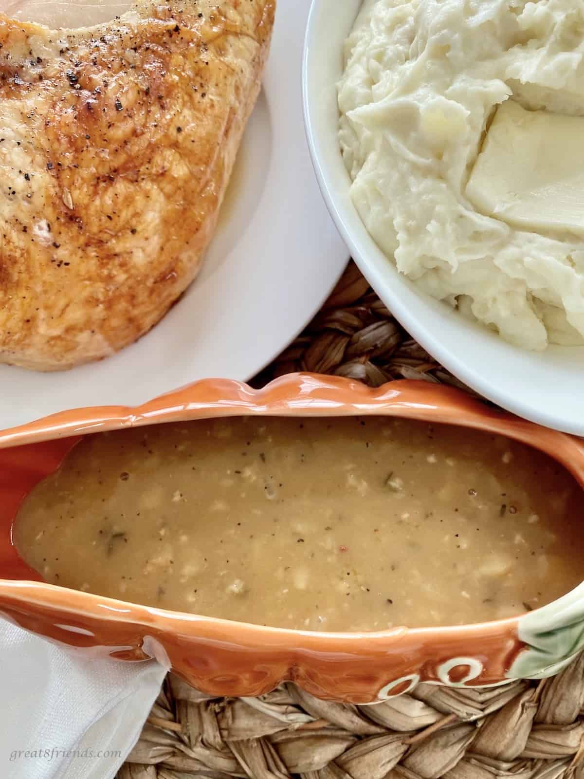 Overhead photo of roasted turkey, mashed potatoes and gravy in a gravy boat.