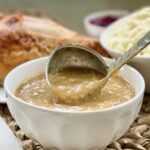 Gravy being served with a ladle.