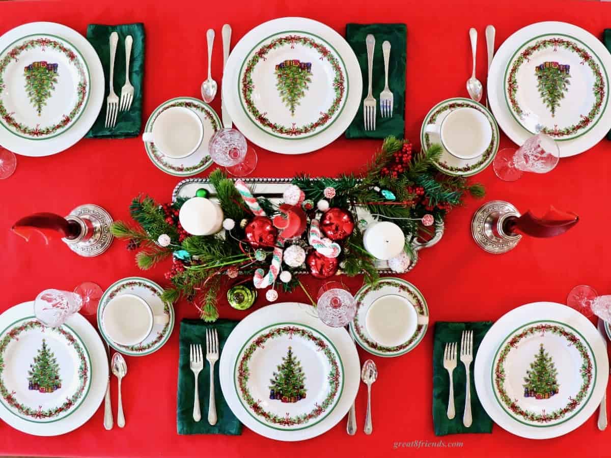 Overhead shot of table set for 6 with Christmas plates and Christmas centerpiece.