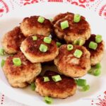 Stack of Danish meatballs garnished with cut green onion.