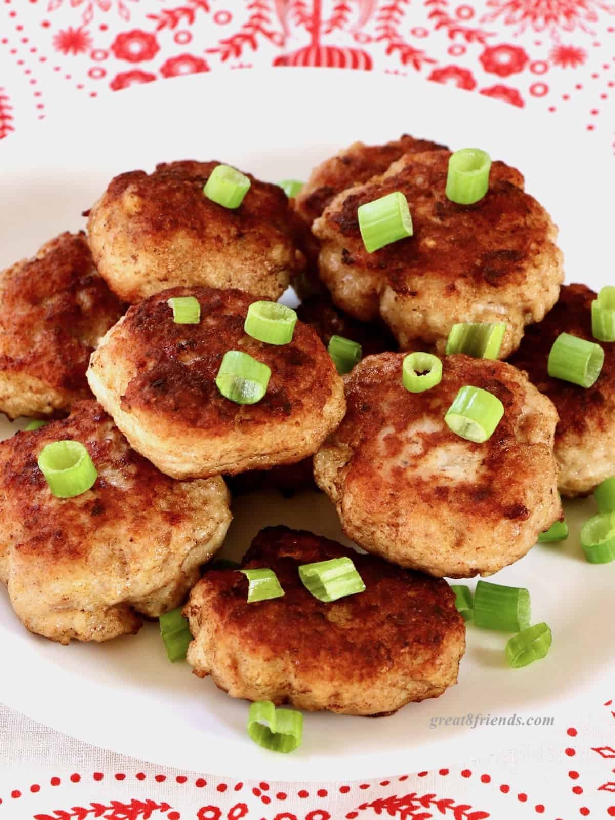 Stack of Danish meatballs garnished with cut green onion.