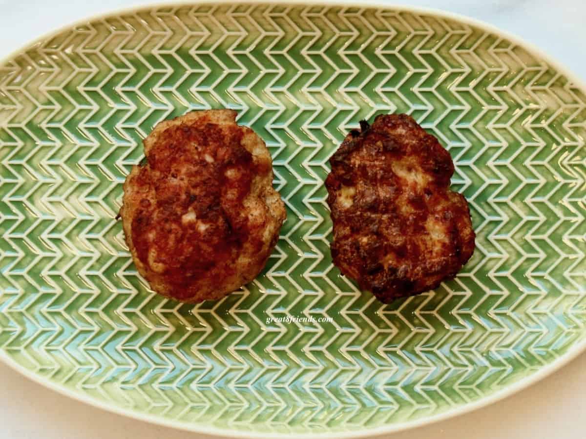 Overhead shot of 2 Danish meatballs side by side on a green oval plate.