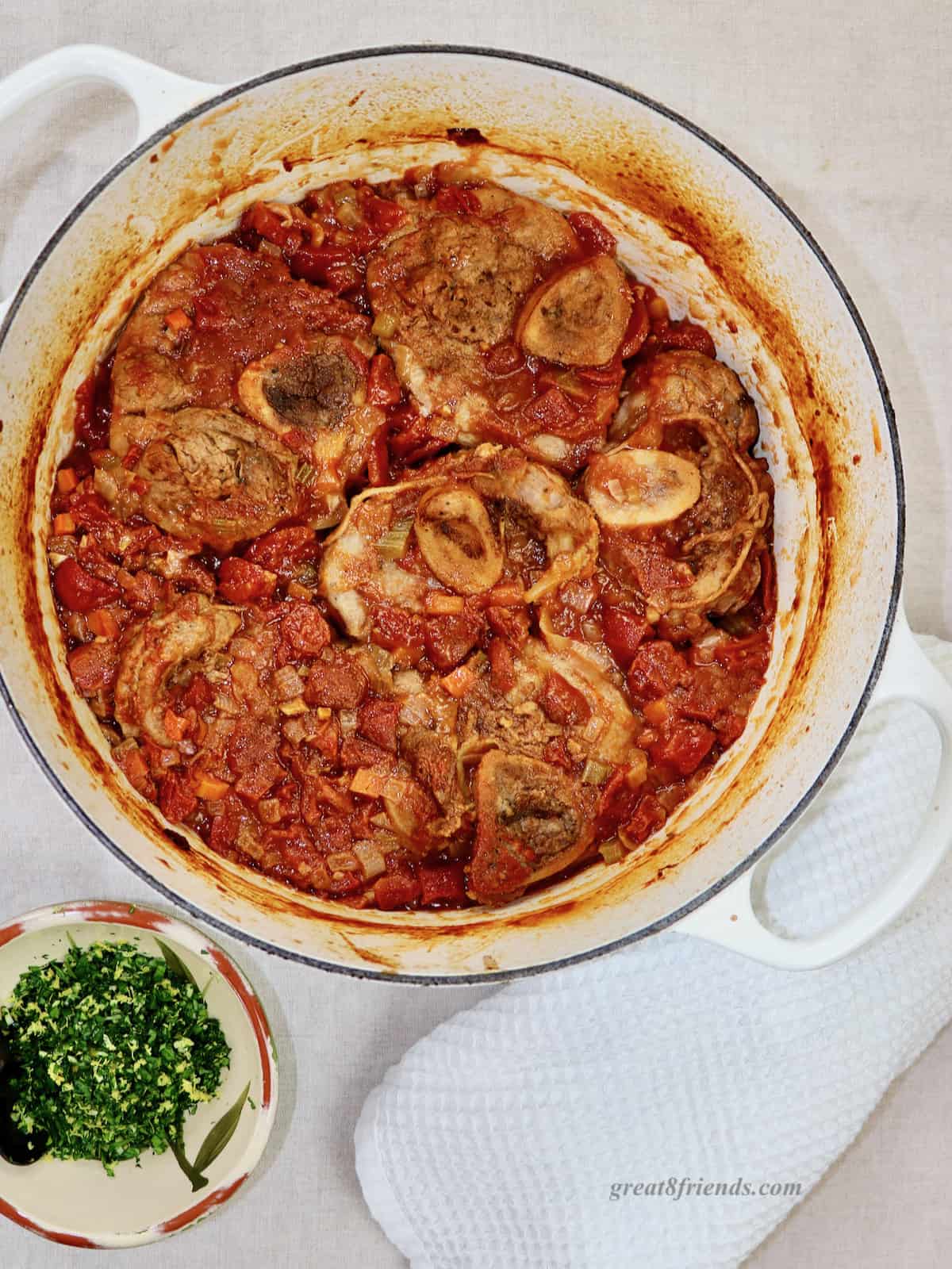 Overhead shot of white pot with osso buco.