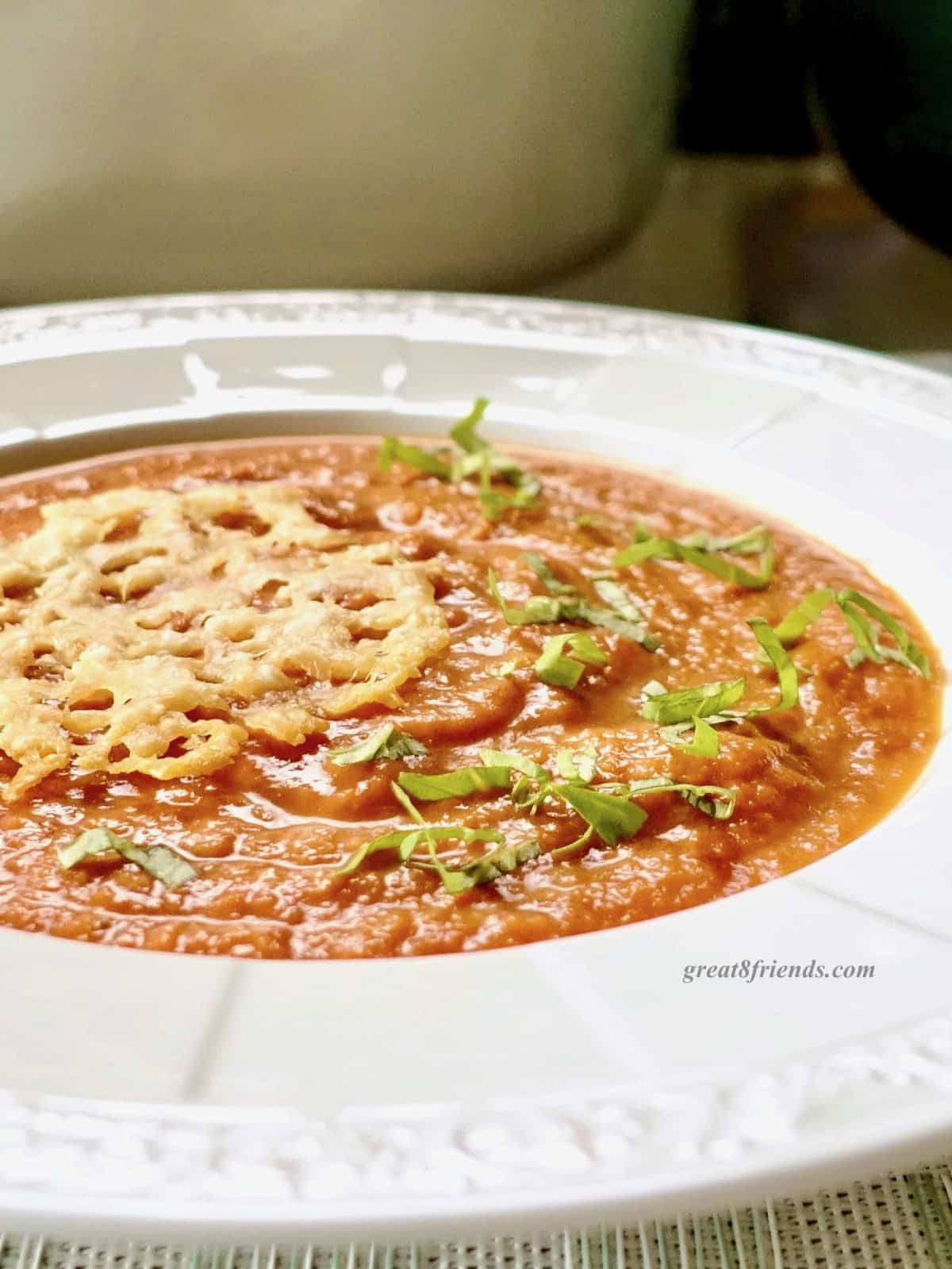 Tomato soup topped with shredded basil and parmesan crisps.