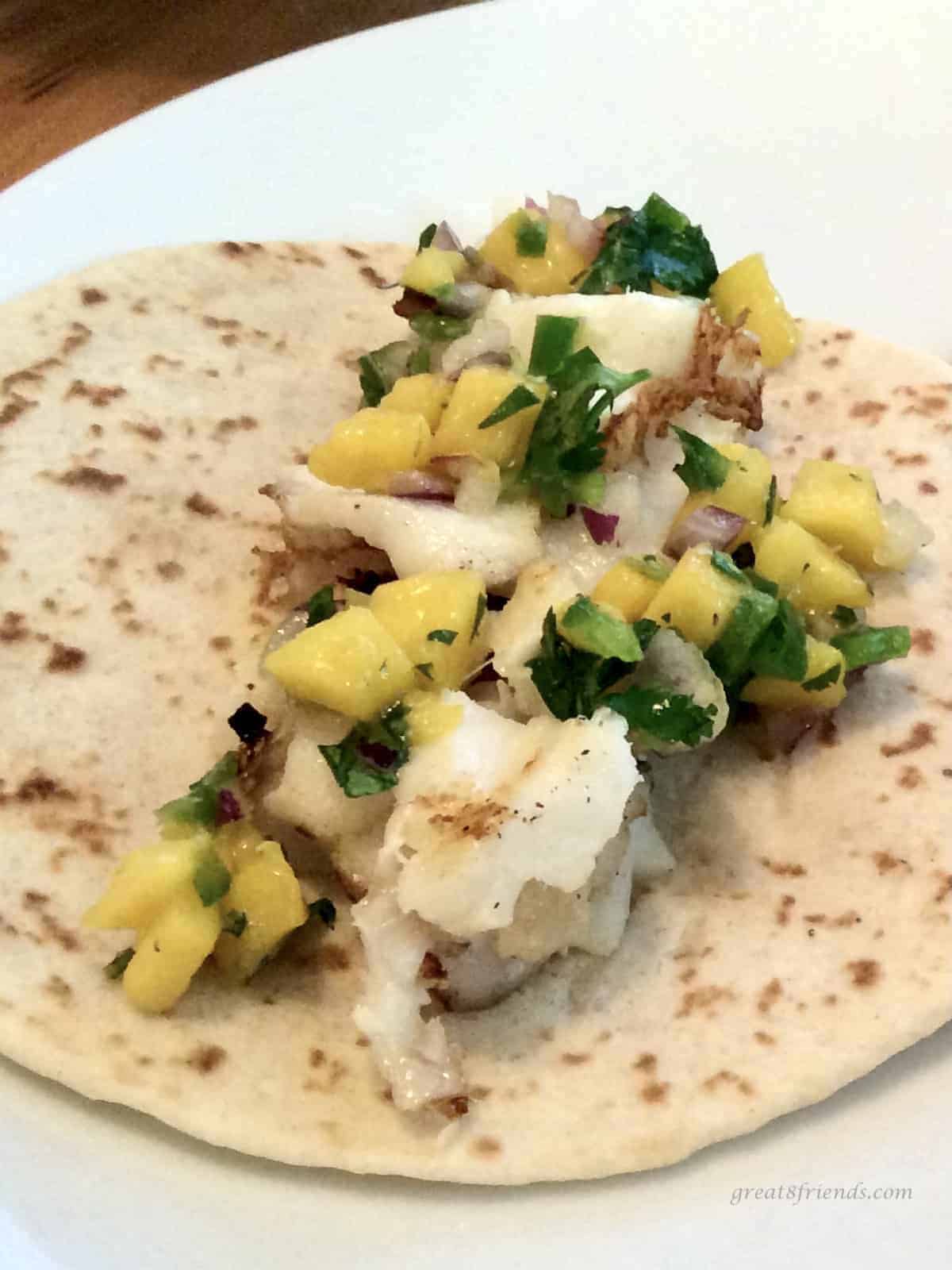 Grilled fish taco with mango topping.