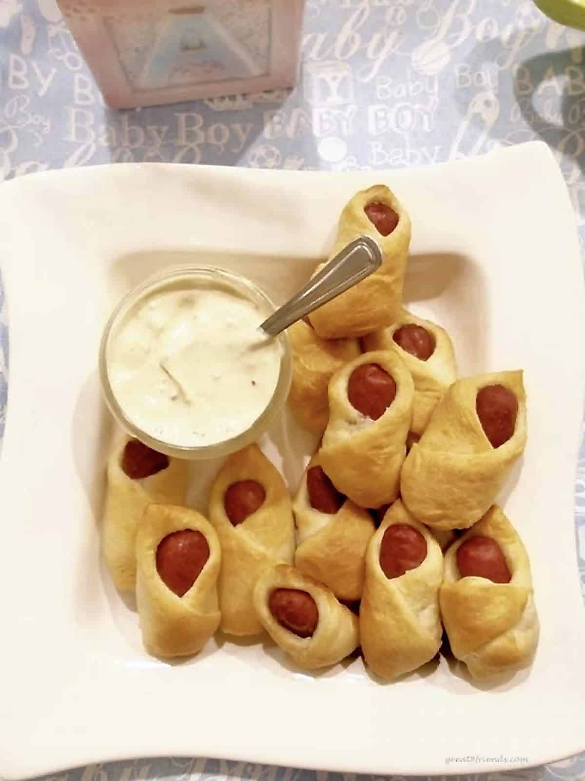 Small beef wieners wrapped in a pastry and served with a sauce on the side.