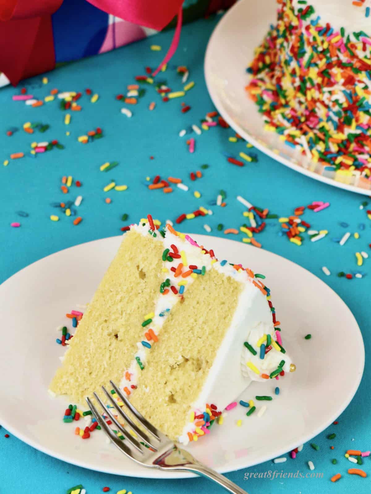 Slice of yellow cake on a white plate.