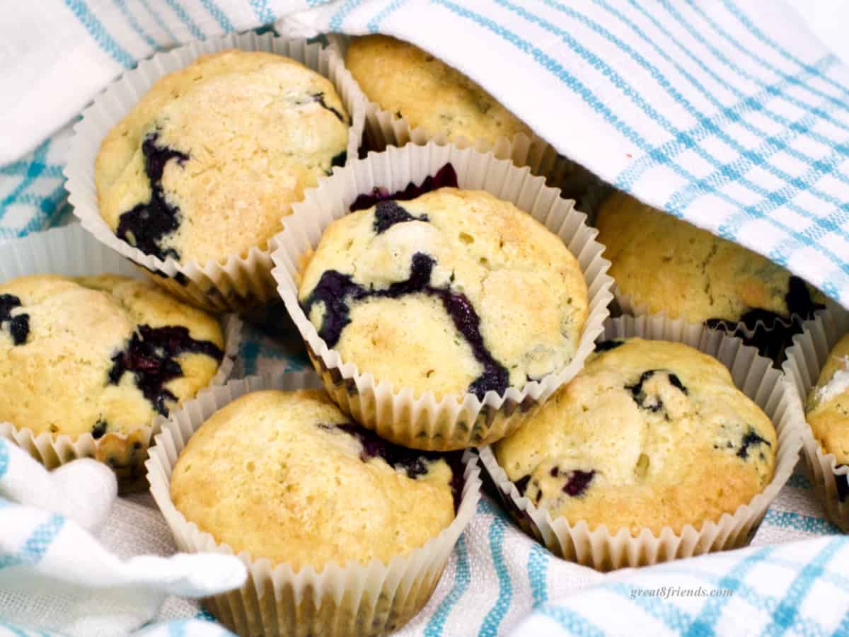 Blueberry Muffins nestled in a blue and white dish towel.