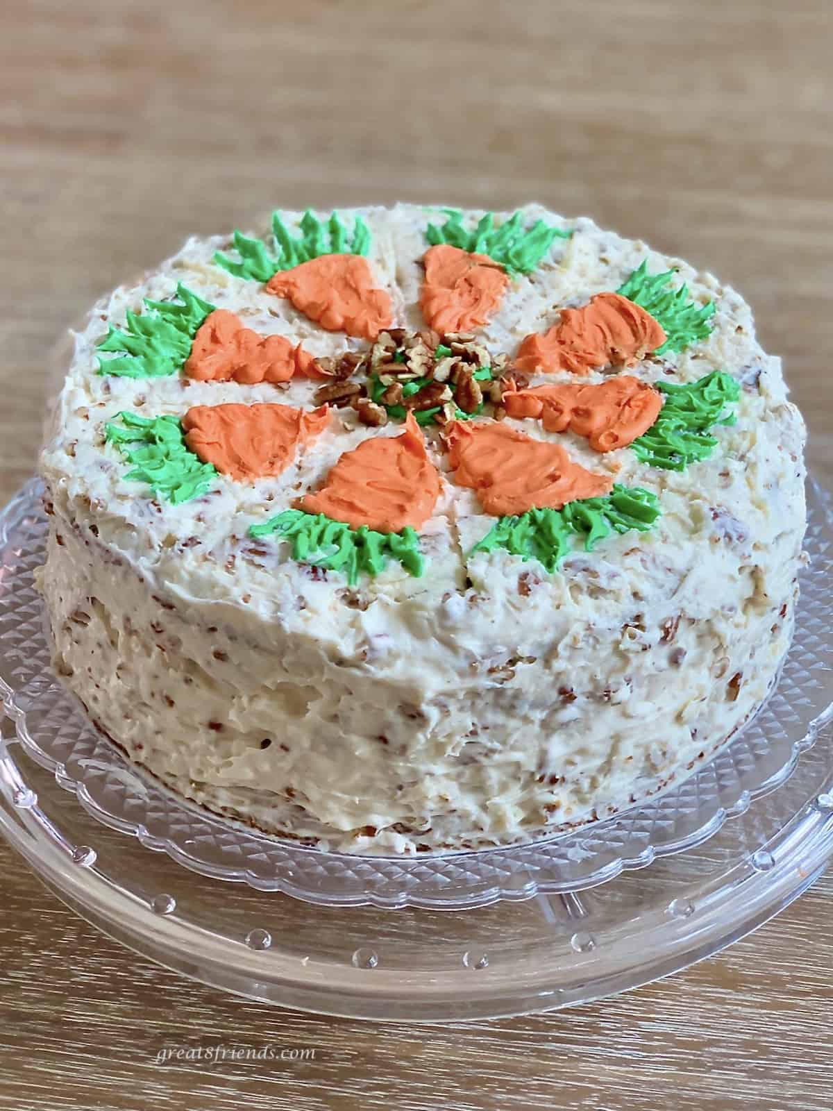 Homemade carrot cake with carrots on the top made of orange and green icing.
