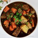 Overhead shot of Irish beef stew in a ceramic serving dish.