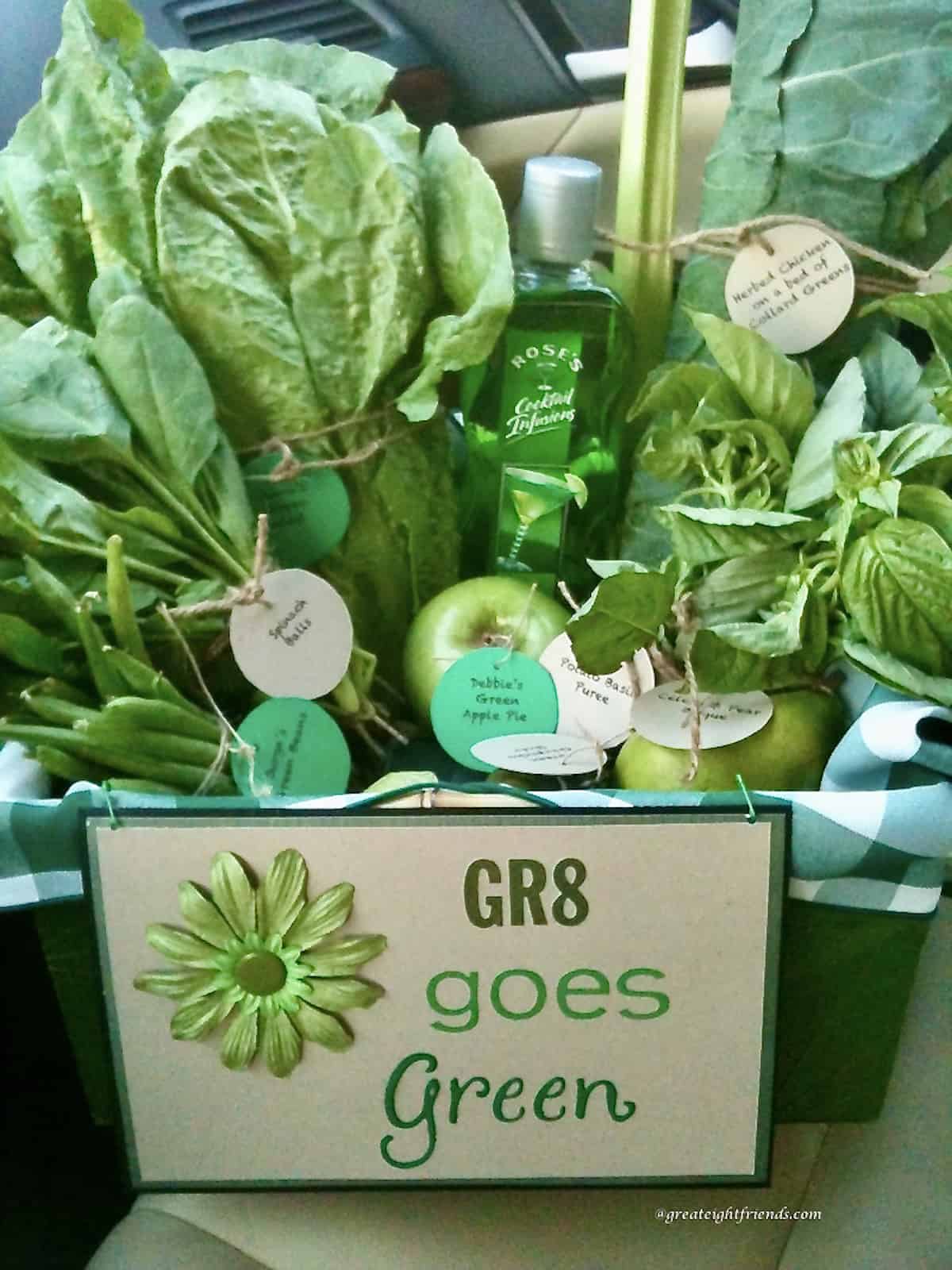 A basket filled with fresh green produce with a sign on the front of it saying, "Gr8 Goes Green".