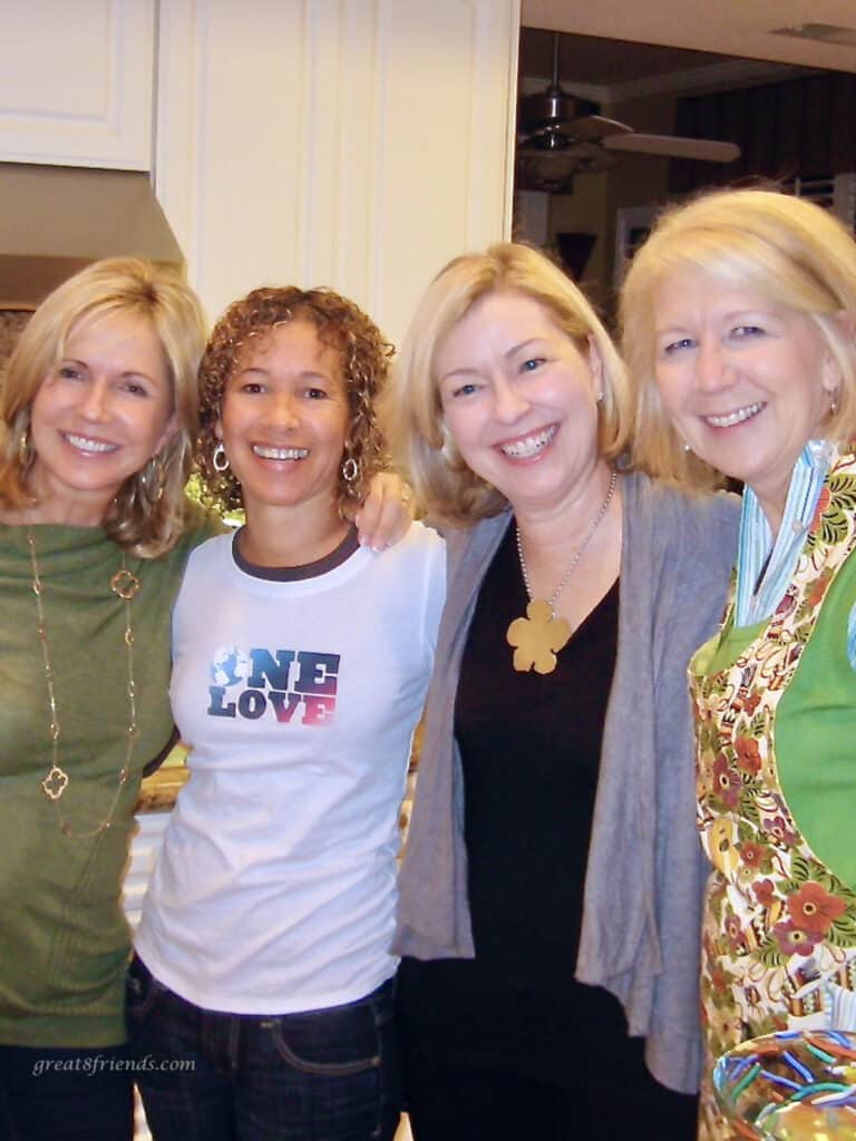 Four women posing with arms around each other posing for the camera.